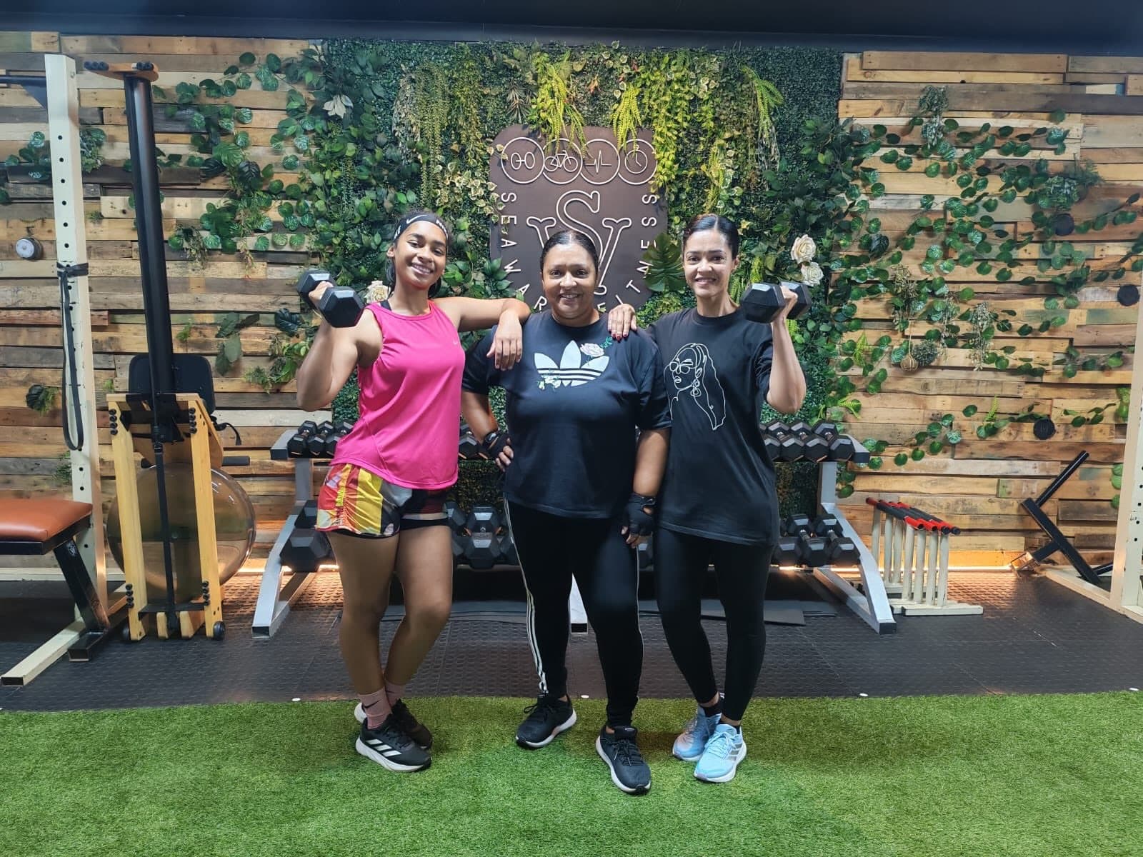 Three members training with dumbbells at Seaward Fitness